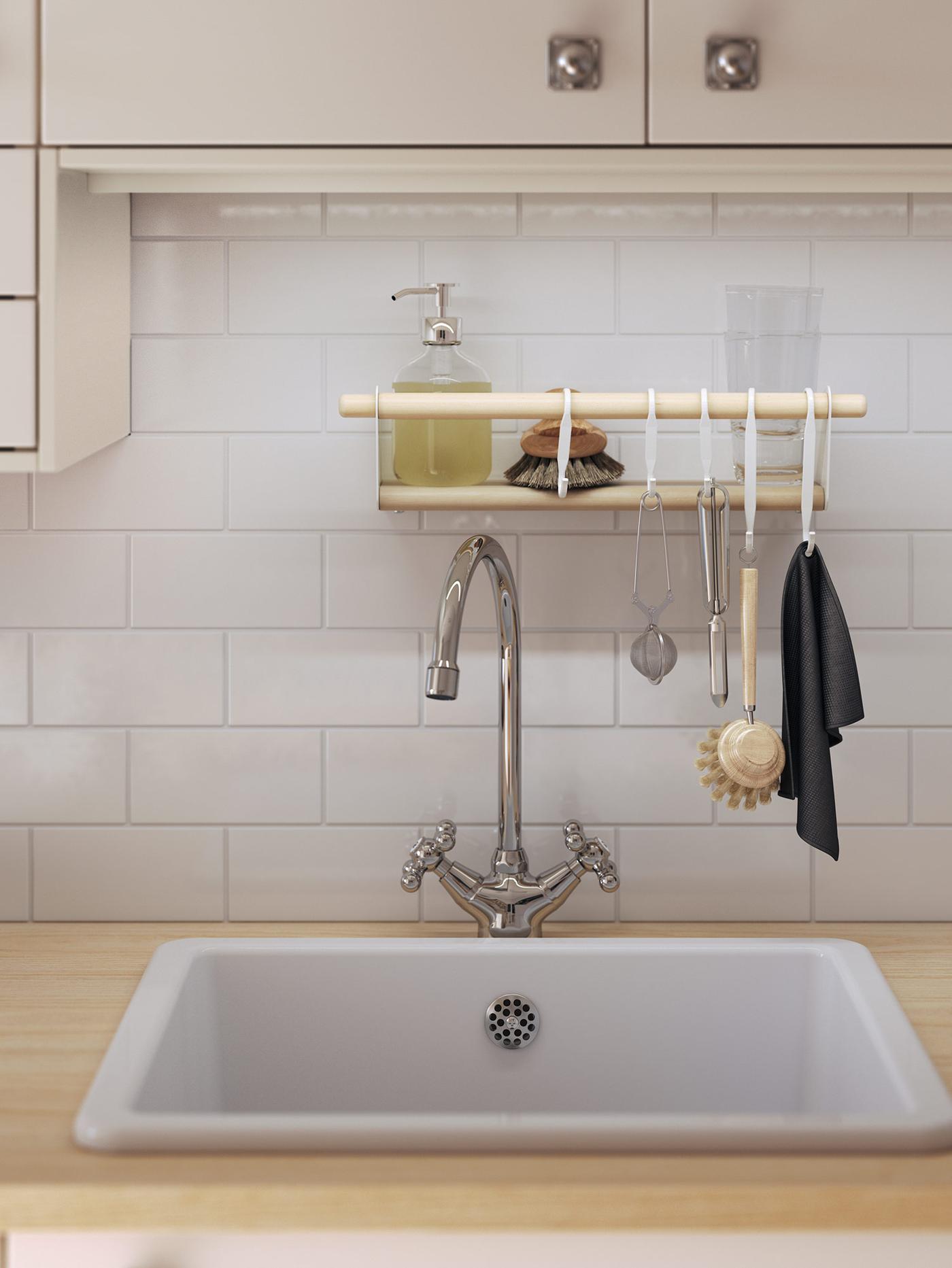 Hvid HAVSEN vask i porcelæn med et nostalgisk blandingsbatteri med kold og varm hane. På væggen hænger en lille hylde med opvaskemiddel og klude