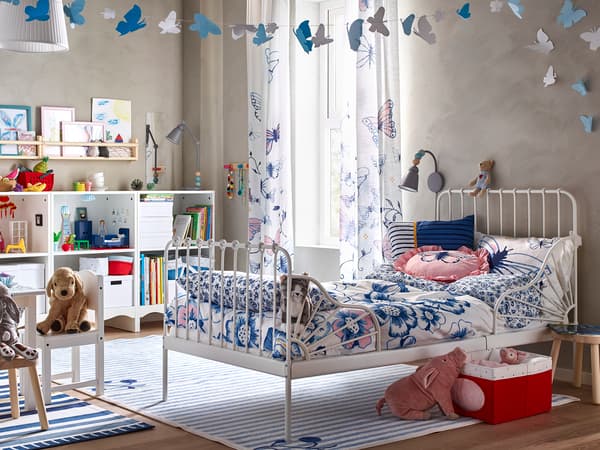 白いベッドにブルー柄の寝具を合わせた子ども部屋。カラフルな装飾と収納で楽しい雰囲気。