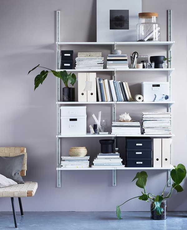 Idée d’organisation pour une chambre d’étudiant, avec bibliothèque remplie de boîtes, de photos et de livres.