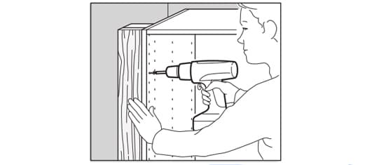Iemand bevestigt een opovulstuk naast een keukenkastje.