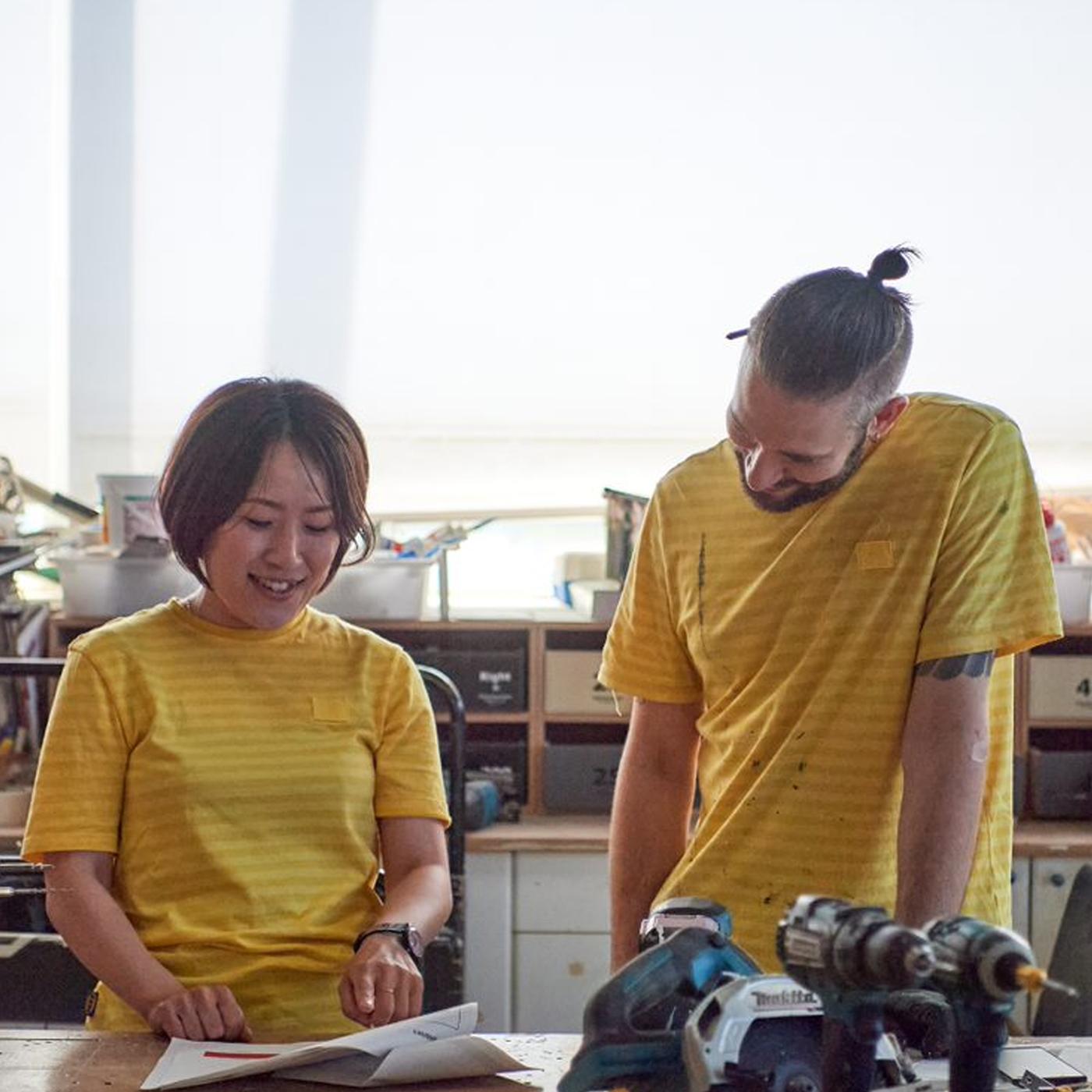 イエローのシャツとブルーのスカーフを身に付けた中年のイケアコワーカーがお客さまと話している。