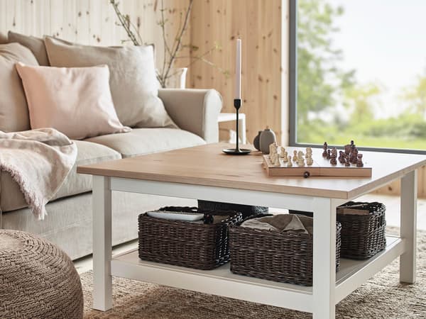 白いフレームに木製天板のコーヒーテーブル。下段にラタンバスケットを収納したナチュラルデザイン。