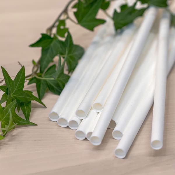 나무 벤치에 놓여 있는 화이트 색상의 IKEA 종이 빨대 12개