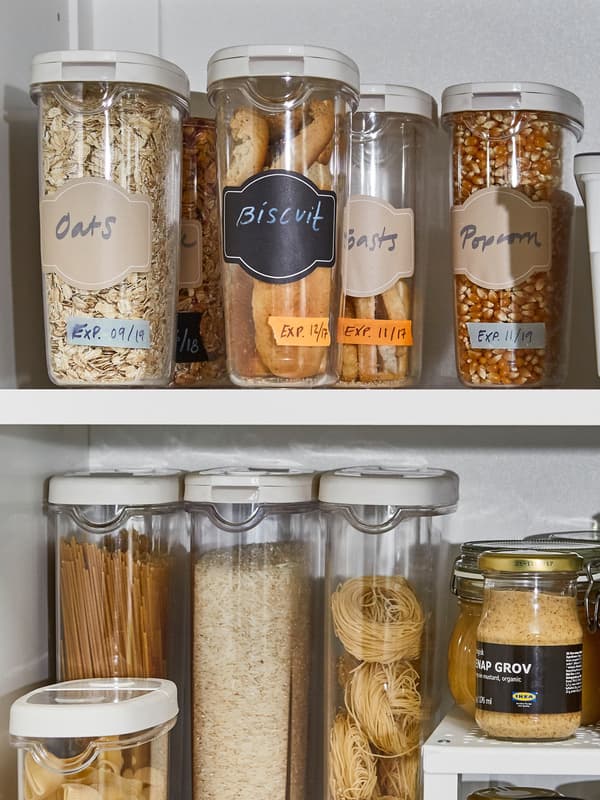 IKEA 365+ dry food jar containers with oats, biscuits, and cereal, inside a white kitchen cabinet.