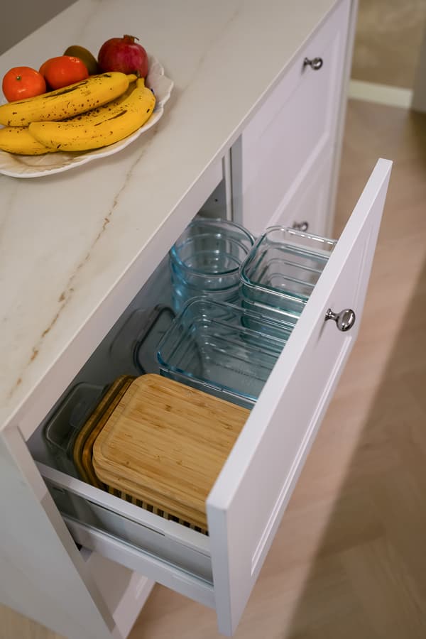 IKEA 365+ -sarjan lasiset ruoansäilytysastiat ja niiden bambukannet on järjestelty siististi vierekkäin keittiön vetolaatikkoon.