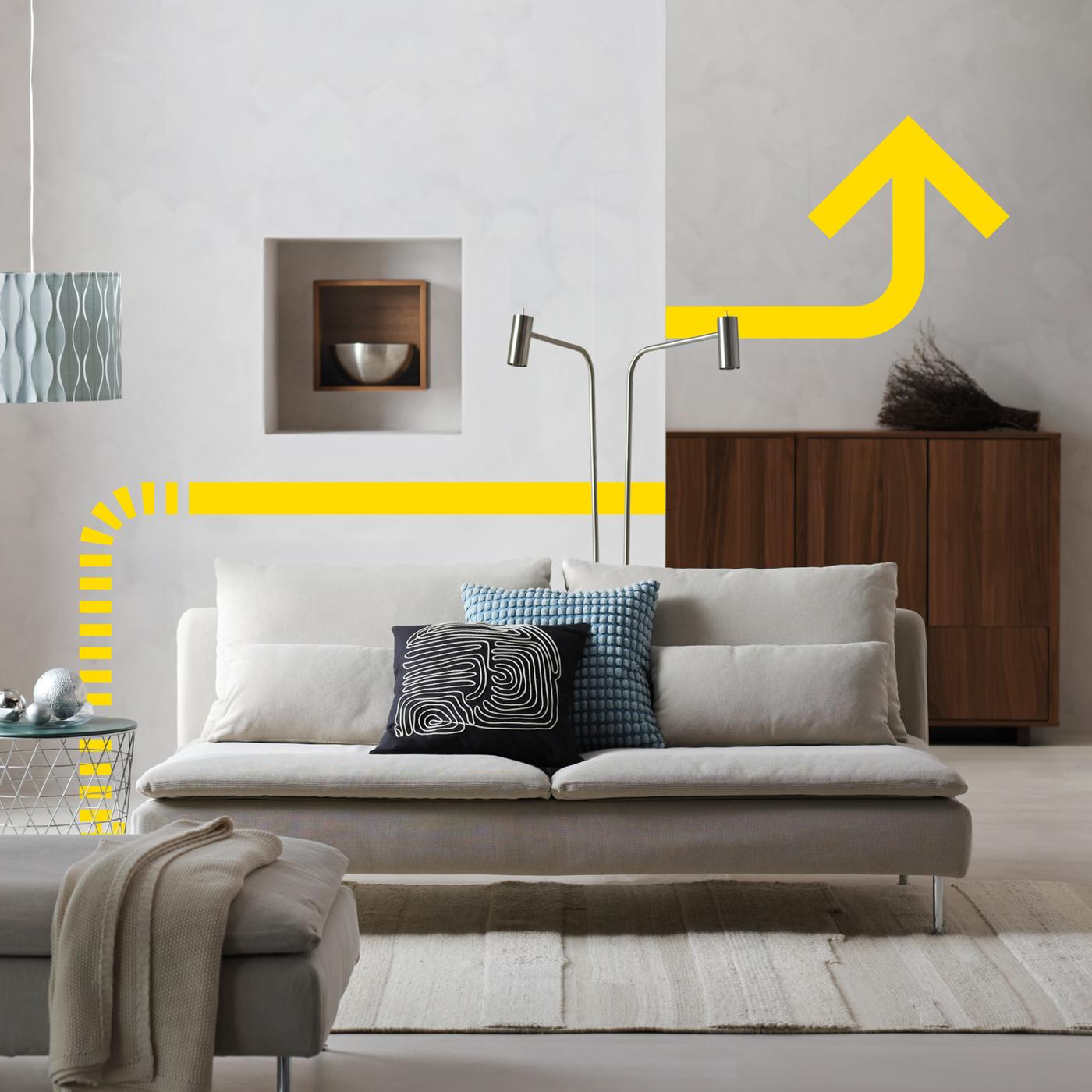 IKEA ärikliendikonverentsi reklaampilt, millel on kujutatud modernne elutuba naturaalvalge diivani, puidust hoiulahenduste ja kollaste graafiliste aktsentidega.