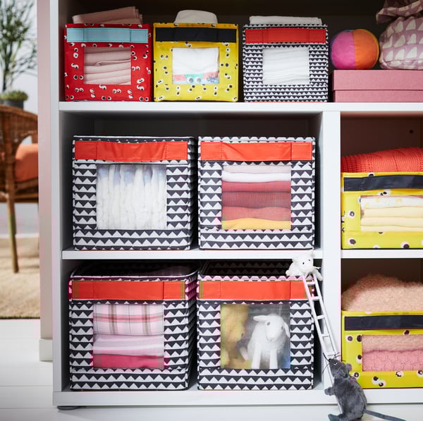 IKEA ANGELÄGEN colourful lidless boxes with transparent fronts in STUVA changing table open storage slots.