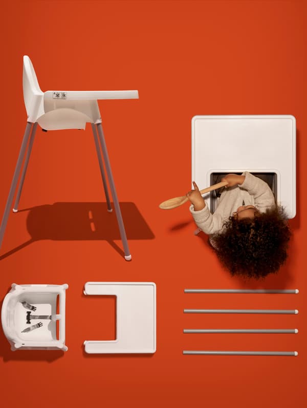 IKEA ANTILOP highchair showing all product parts laid out on an orange background including baby sitting with a wooden spoon.