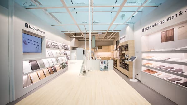 IKEA-Ausstellungsbereich mit verschiedenen Küchenfronten und Arbeitsplatten in einem hellen Showroom