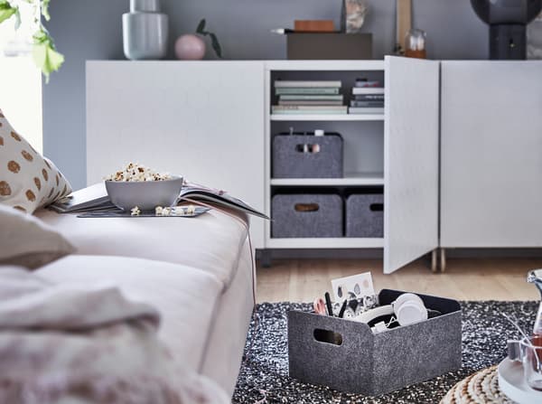 IKEA BESTÅ sorozat VASSVIKEN méhsejtmintás ajtóval, sötétszürke filc tárolódobozokkal.