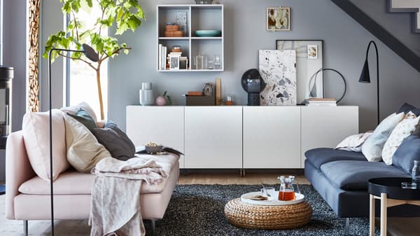 IKEA BESTÅ vit, lågt skåp med EKET hylla i vardagsrum med rosa soffa.