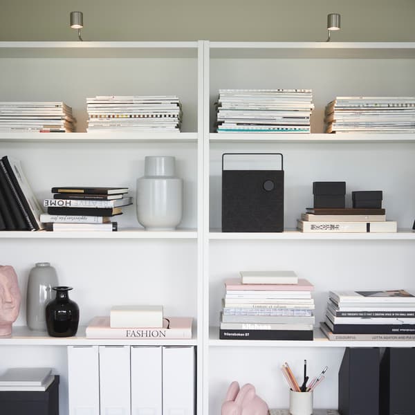 IKEA BILLY white bookcase shelves, arranged with vases and horizontally stacked books.