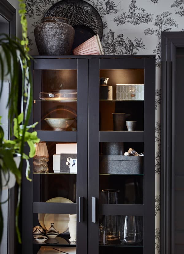 IKEA BRIMNES black cabinets with frosted glass doors, storing boxes and glassware inside.