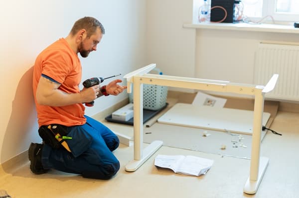 IKEA brīvprātīgais montē gultu gaišā telpā.