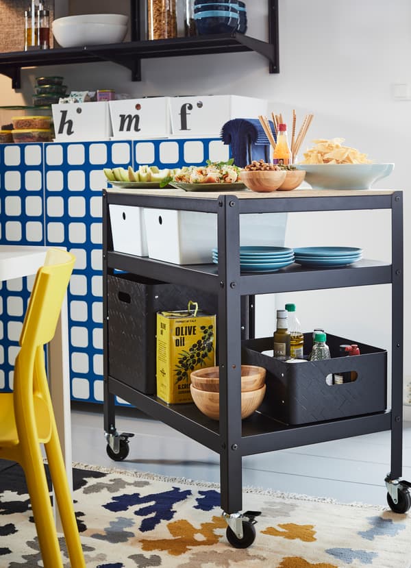 바퀴가 달린 IKEA BROR 브로르 블랙 카트는 하단 선반 2개, 부드러운 소나무 합판 상판으로 이루어졌어요. 아래에 테이블웨어와 수납함, 바구니를 담고 집안 어디든 끌고 갈 수 있어요.