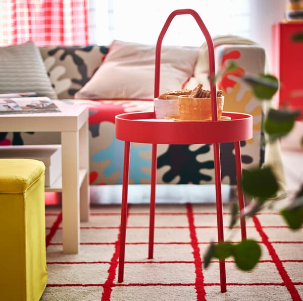 IKEA BURVIK red side table iholding snacks on its circular tray.