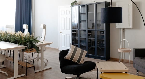 IKEA business showroom with green plant wall, black high tables, and modern office furniture display