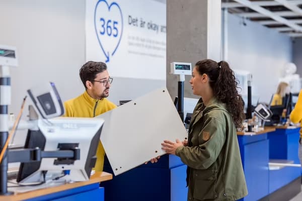 IKEA co-worker helping a customer with a return in the warehouse.
