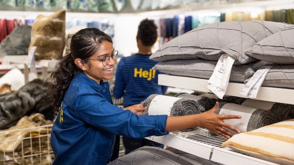 IKEA co-worker restocking product in textiles department
