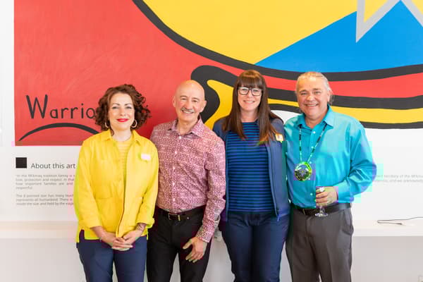 IKEA co-workers and community members standing in front of a mural in the IKEA store. 