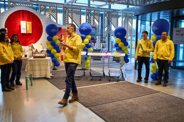 IKEA co-workers standing near Wembley store entrance in yellow uniforms, listening to celebratory speech from store manager