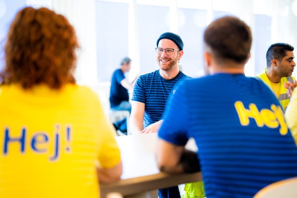 IKEA co-workers wearing dark blue uniforms plating up meals in the restaurant.