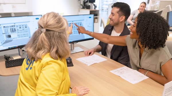 IKEA coworker helping two customers plan a system on a desktop