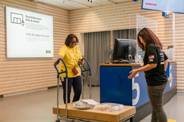 IKEA coworker is helping the customer to register their items for delivery