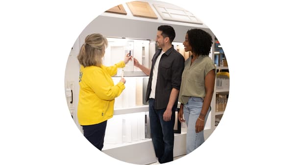 Ikea coworker showing two customers cabinet door options