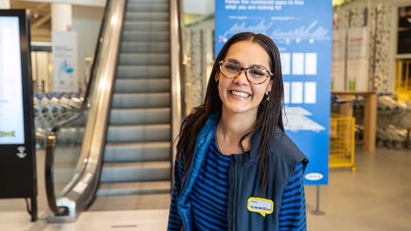 IKEA Coworker smiling and standing in front of an escalator
