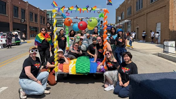 IKEA coworkers outside surrounding an LGBTQIA+ parade float 