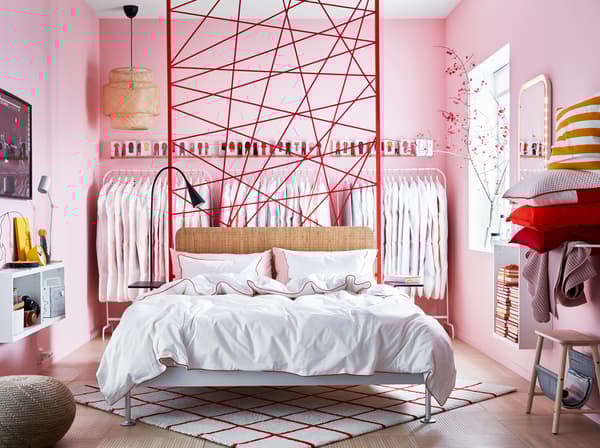 IKEA DELAKTIG bedframe sits in the middle of a pink walled bedroom.