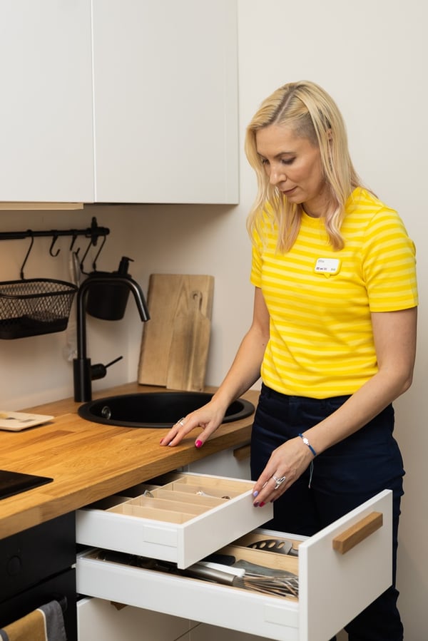 IKEA Designer opening a kitchen drawer with a built-in cutlery organiser.