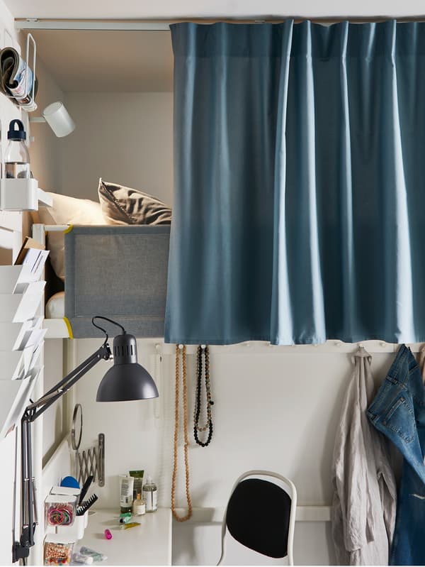 IKEA DITTE light blue fabric, as a curtain, just revealing a bed and some pillows.