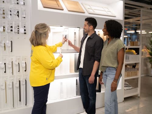 IKEA employee in a yellow jacket helping customers