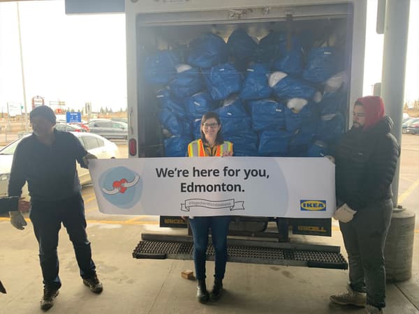 IKEA employees holding a banner reading 'We're here for you, Edmonton'.