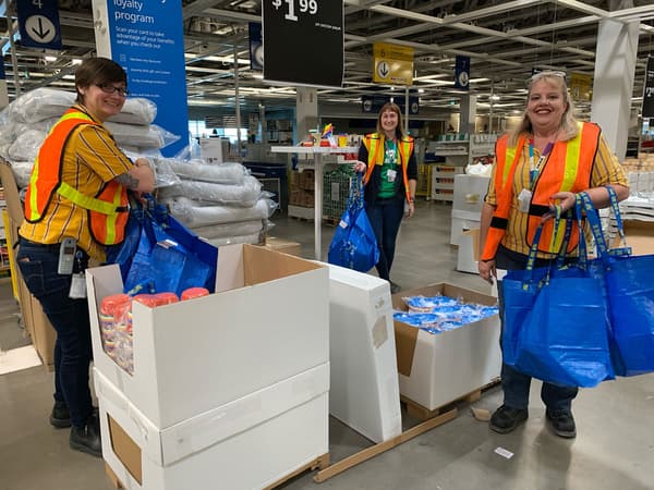 IKEA employees with boxes and bags full of donated items.