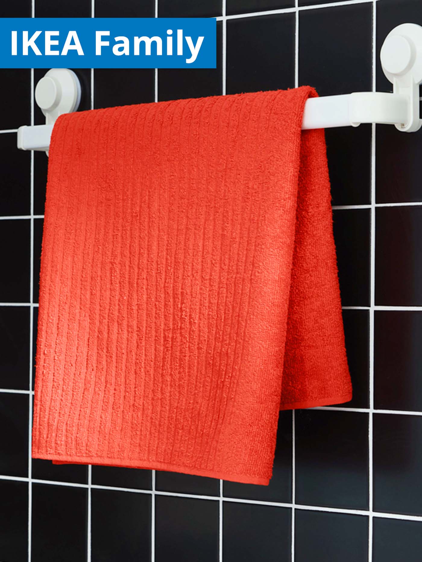 IKEA Family offer. VAGSJON bath towel, 140 cm, orange-red, hanging on white TISKEN towel rack in the bathroom.