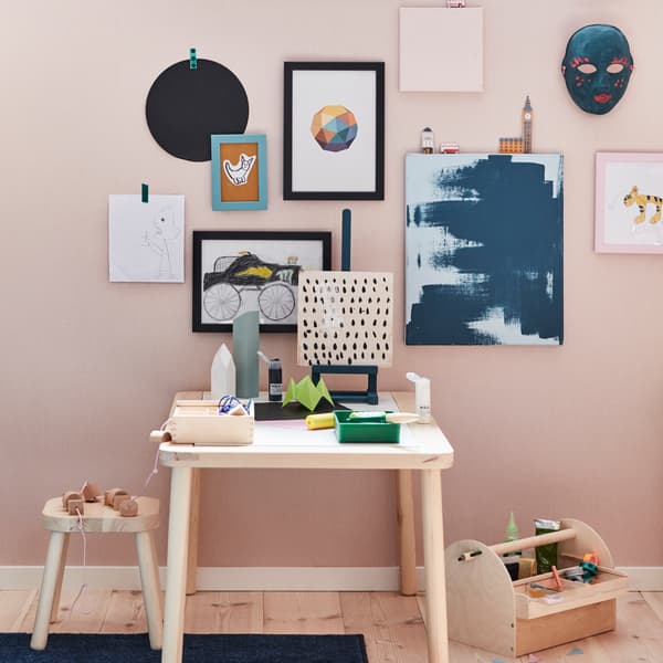 IKEA FISKBO pink and black picture frames displaying children's artwork and graphic prints.