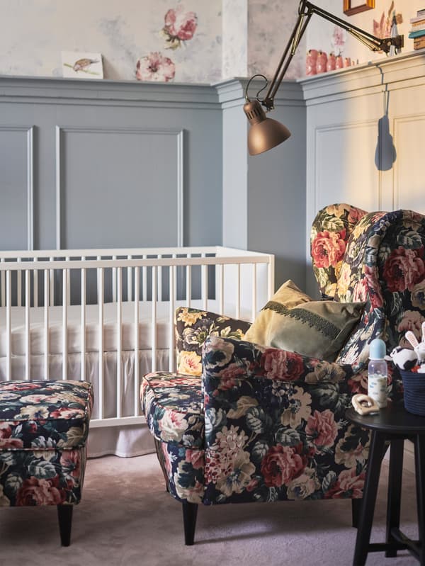 IKEA floral patterned armchair next to a white cot.