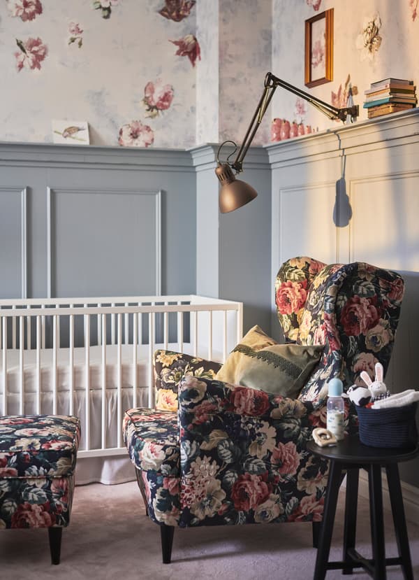 IKEA floral patterned armchair next to a white cot.