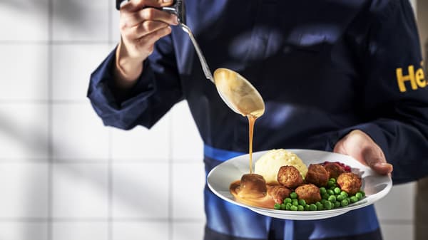 IKEA food coworker spooning gravy over a plate of meatballs