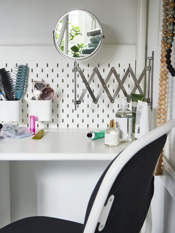 IKEA FRÄCK stainless steel mirror mounted on the wall by a beauty station.