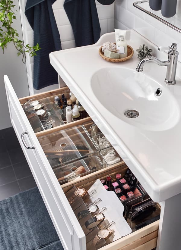 IKEA GODMORGON smoked plastic organiser boxes help keep loose cotton swabs, makeup, accessories and bathroom tools in check. The clear lids have a cirular hole on top so you can lift lids with just a finger.