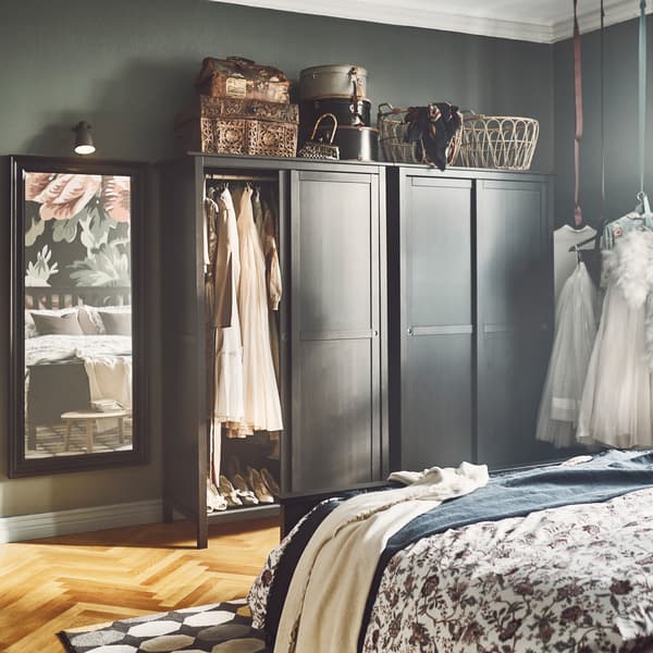 IKEA HEMNES stained black solid pine open wardrobe with sliding doors revealing clothes inside. (currently available in White stain)