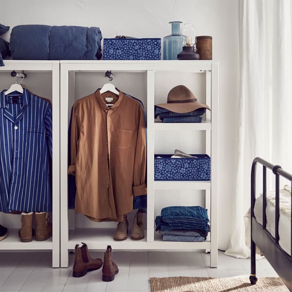 IKEA HEMNES white stained, open, solid wood, wardrobes packed with blue and brown clothing, hats and shoes.