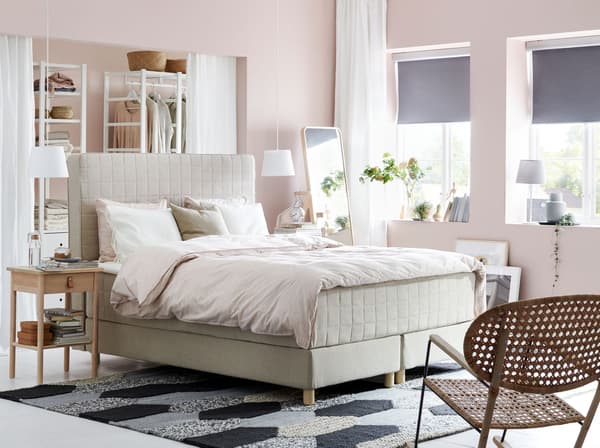 IKEA HOMMELVIK 홈멜비크 베이지 디반침대와 패브릭 침대헤드가 핑크 톤의 침실 중앙에 과감하게 배치된 모습