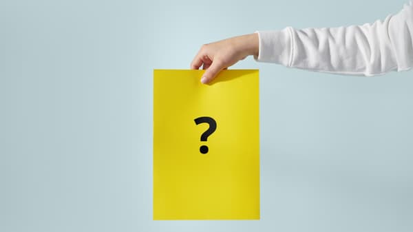 유니폼을 입은 IKEA 직원이 노란색 IKEA 가방을 들고 IKEA 매장 계단을 내려오며 고객에게 인사하는 모습.