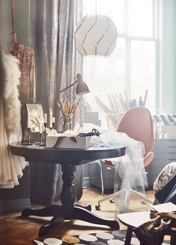 IKEA INGATORP black extendable table in the middle of a bedroom and crafting project.