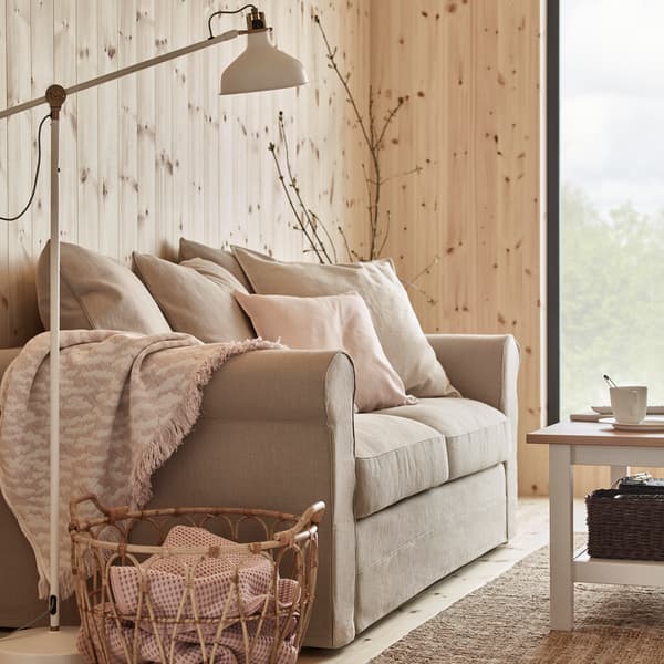 IKEA KAPASTER soft white and pink patterned throw blanket and SNIDAD rattan basket with handwoven fibers.